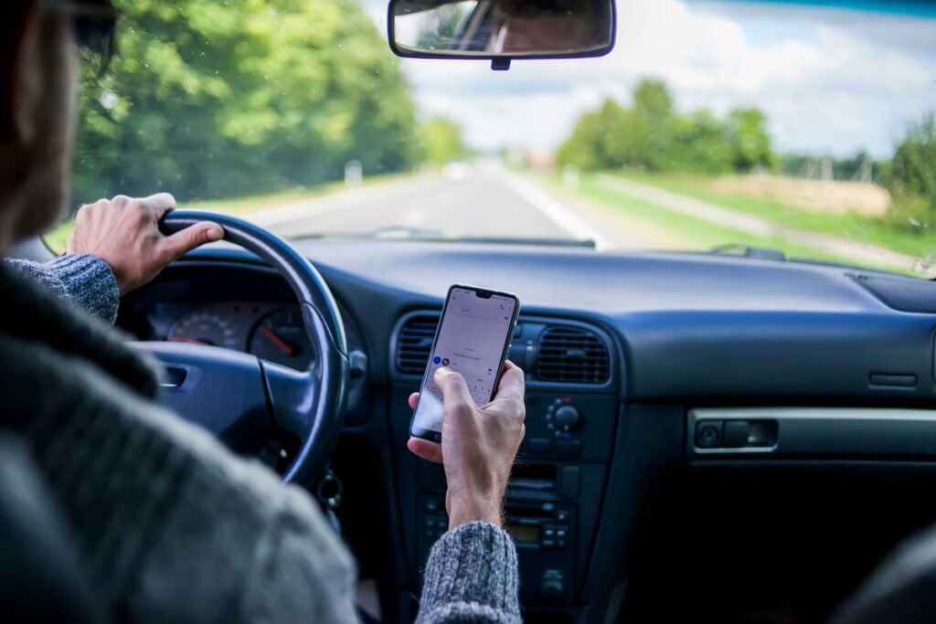 injury lawyer denver, man on phone driving