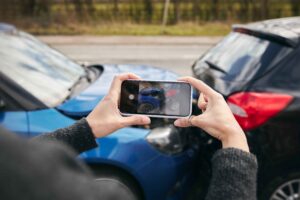 What to do after a car accident: Driver taking picture of crash on phone